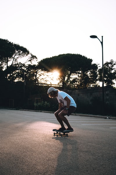 在空旷的道路中间，一名男子正在玩滑板